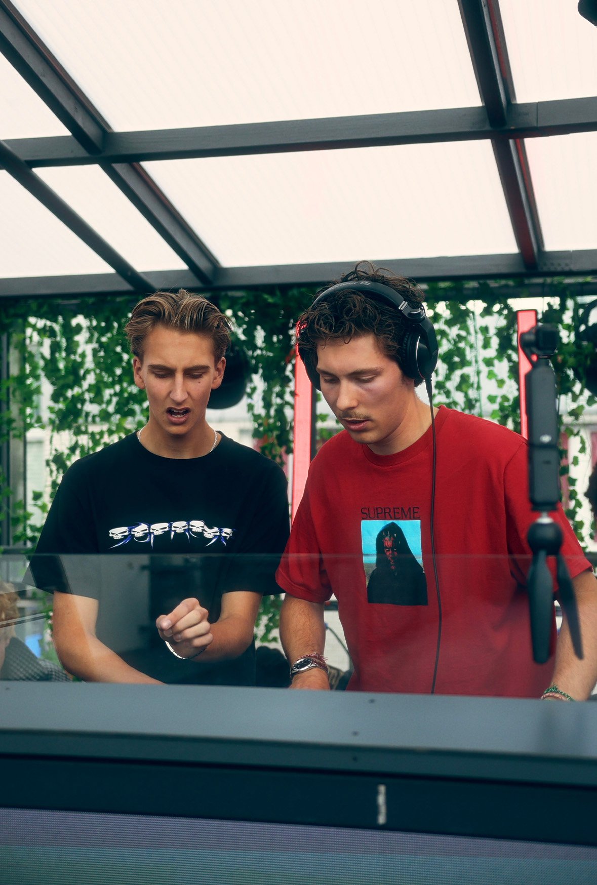 FØR U duo with headphones mixing together at an open-air terrace booth surrounded by greenery