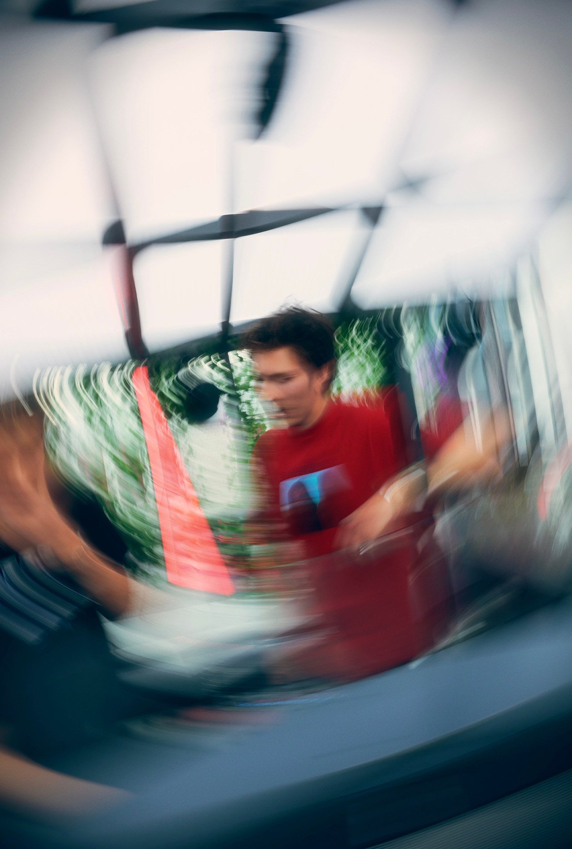 Motion blur shot of a FØR U DJ in a red T-shirt at the decks on an open-air terrace